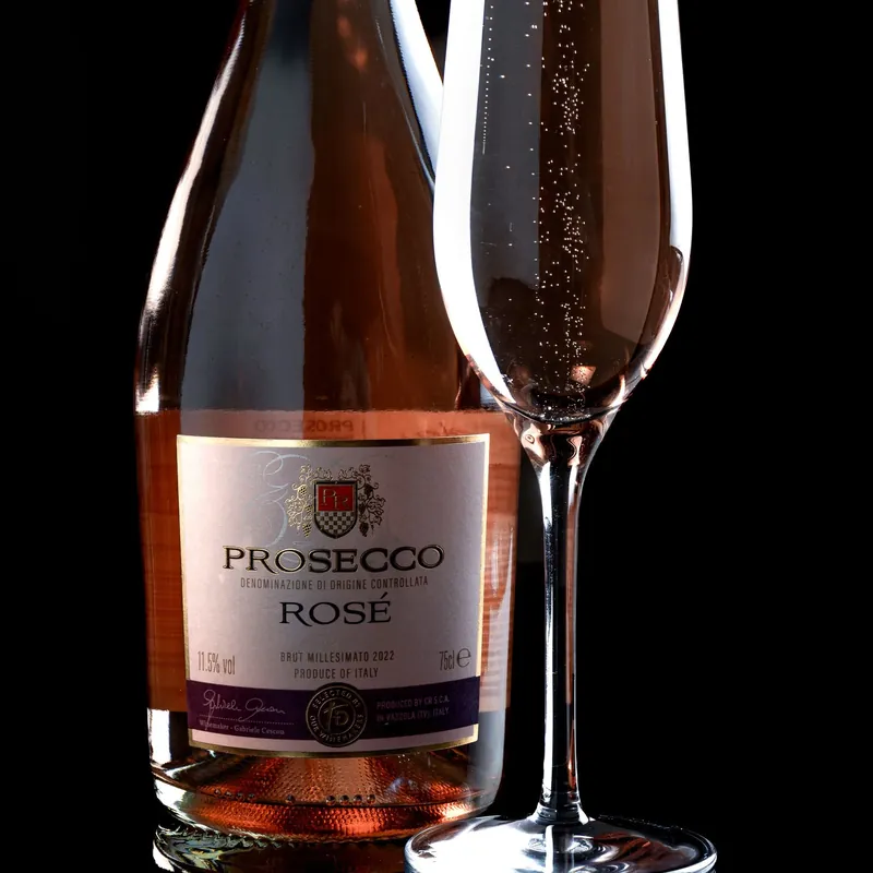 Botella de espumante rosé con copa